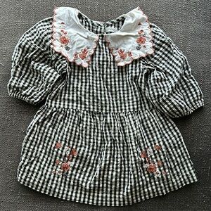 Toddler Next checkered dress with embroidered flowers and hints of gold.